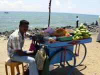 Seller at the beach with various salads
