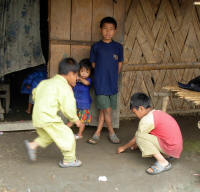Boys playing a game where coins must be thrown into a small depression in the ground.
