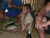 Young boy eating the main meal of rice (Jay)