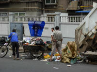 Garbage is brought by collectors using bicycles to the big garbage truck