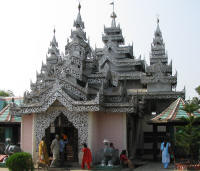 Buddhist Temple flanked by plaster elephants and candle pavilions