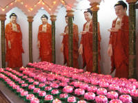 Bodhisattvas with candles purchased by devotees
