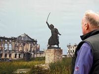 Pieter looking at a photo of the Jan Kilinski Monument in war ravaged Krasinski Square